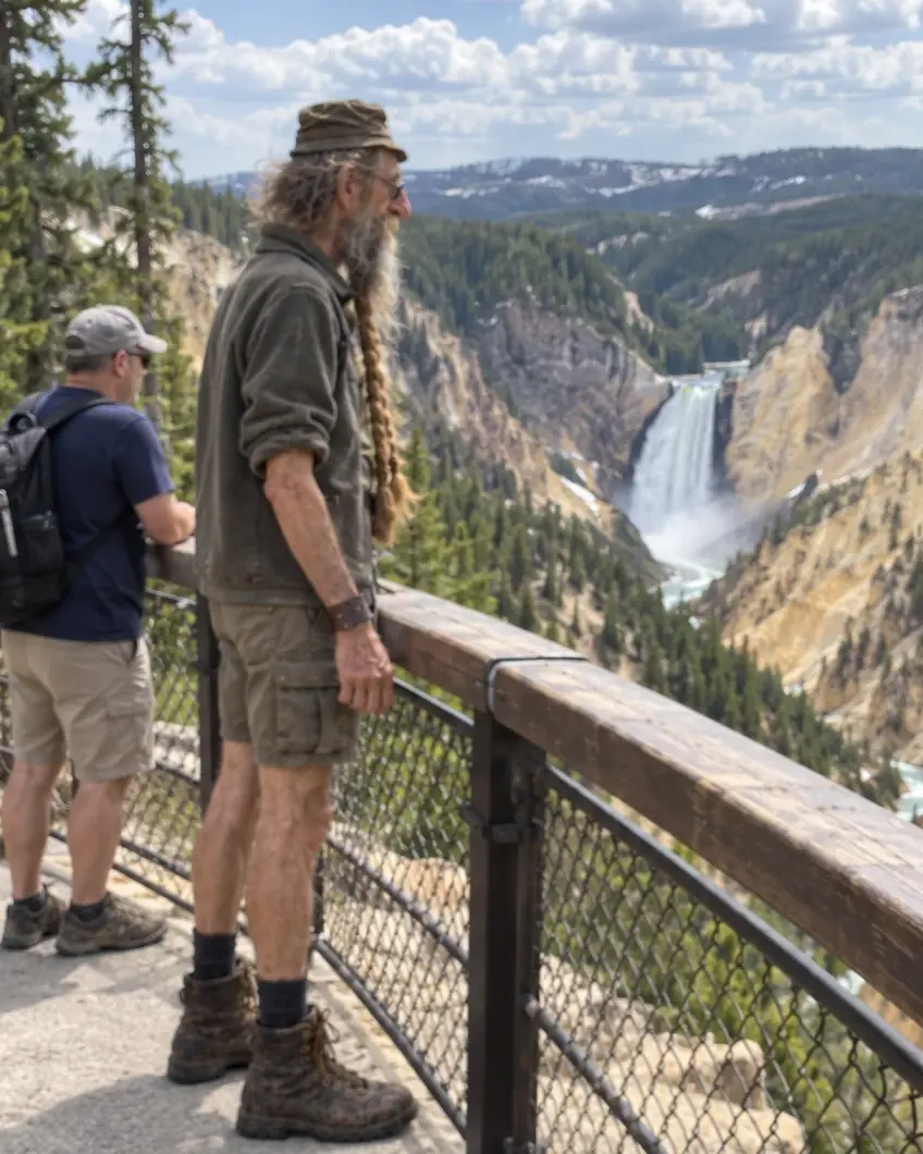 Walter at a canyon lookout, watching a tall waterfall fall between yellow cliffs